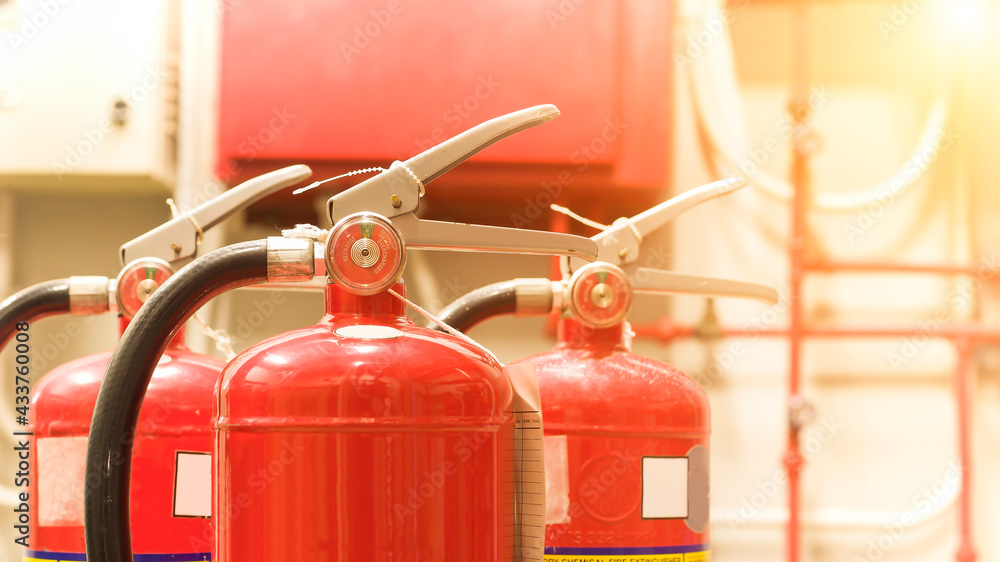 The red fire extinguisher is ready for use in case of an indoor fire emergency. The red fire extinguisher is ready for use in case of an indoor fire emergency.