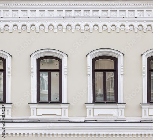 Vintage architecture classical facade building. Windows framed in architectural  Russian style decor. Front view.