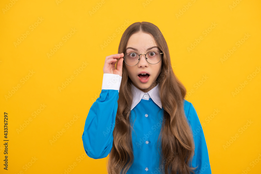 Surprised teenage girl fix eyeglasses yellow background, surprise Surprised teenage girl fix eyeglasses yellow background, surprise