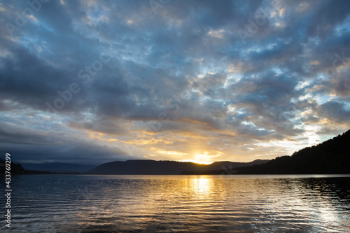 Lake Mapourika in New Zealand surrounded by nature, sunset with beautiful colourful cloudes photo