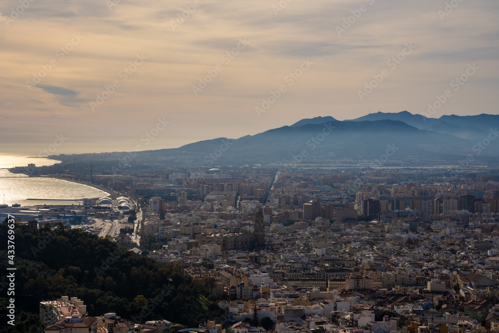 Beautiful landscape of the historic center of Malaga next to the port and the mountains at sunset. European city city next to the Mediterranean Sea.