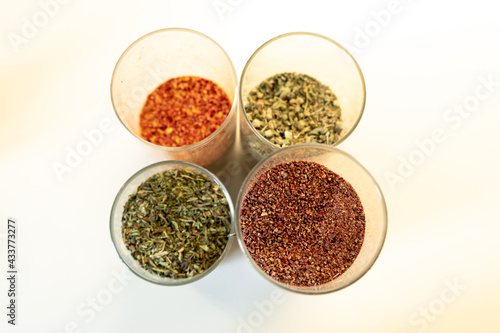 Spices in glass jars. Sumar, chili peppers, thyme and mint. Turkish food spices. Selective focus, top view.