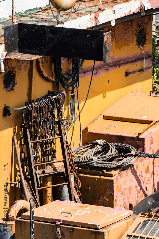 a hydraulic ship in the harbor of hamburg photographed in bright sunshine with strong colors and rusty textures