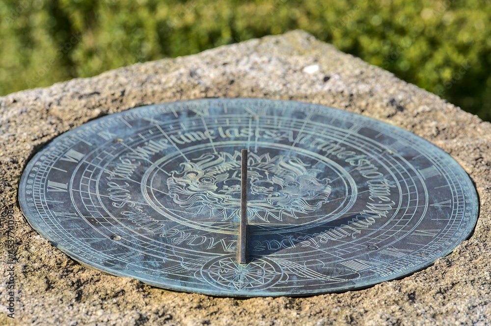 Beautiful closeup view of timekeeping device sundial on stone stand on university campus, Dublin, Ireland. Soft and selective focus