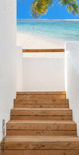 Escalier bois et balcon ouvert sur plage paradisiaque  © Unclesam