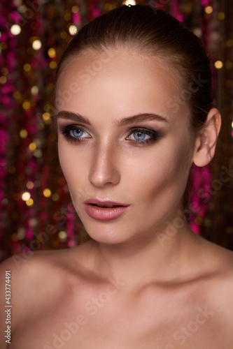 Beauty portrait of a High Fashion model woman in colorful bright neon lights posing in studio, night club On colourful vivid sequin background.