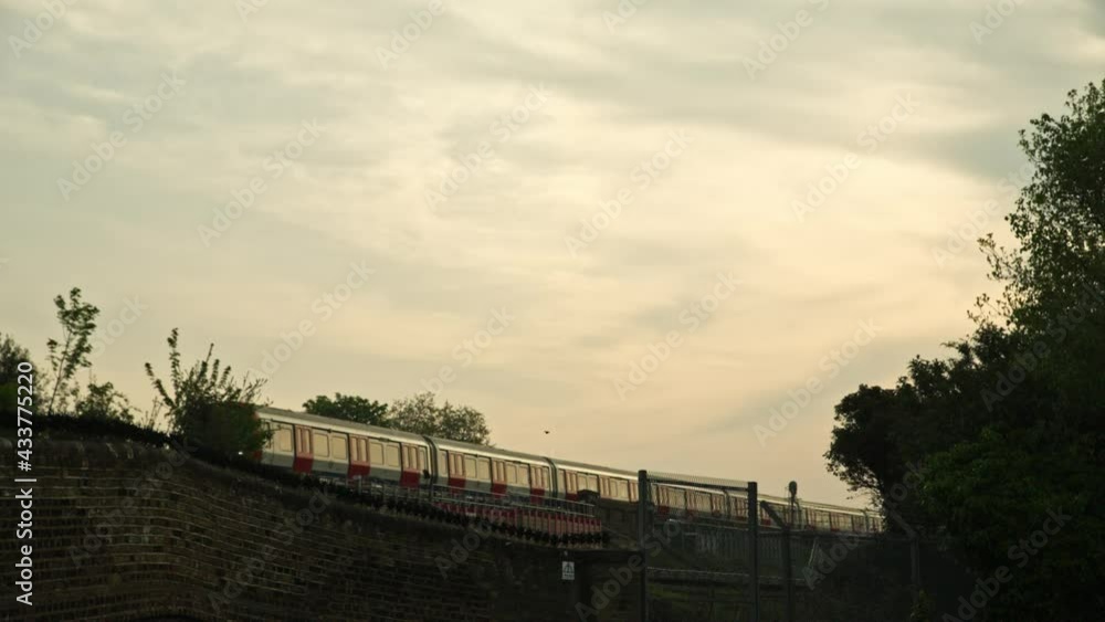 A commuter train passes beneath a dawn sky. A commuter train passes beneath a dawn sky.