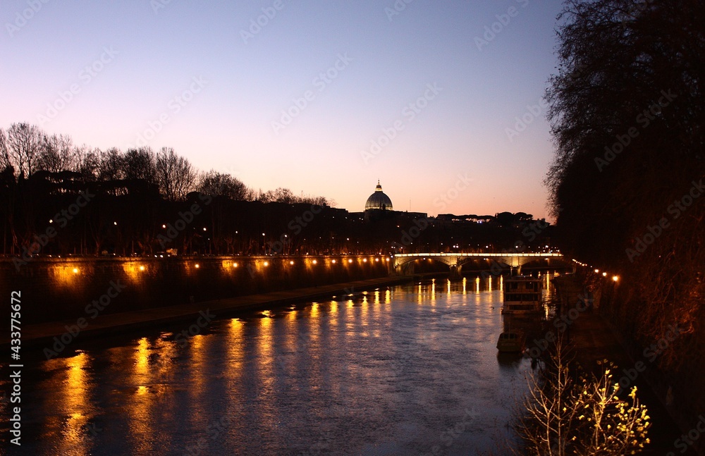 view of a cathedral at sunset over a river in rome