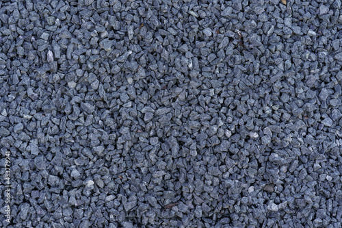 Gray small rocks ground texture. Dark gray small road stone background. Gravel pebbles stone seamless texture.