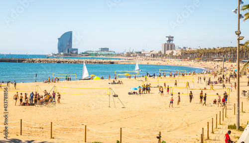 Beautiful picture of Barcelona beach plenty of people enjoying  the sun and summer playing beach sports. photo