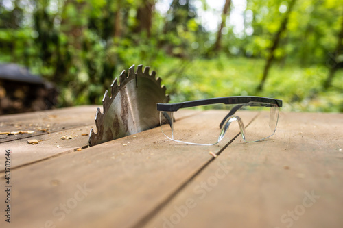 Arbeitsschutz beim Holz sägen mit der Kreissäge durch eine Schutzbrille 
