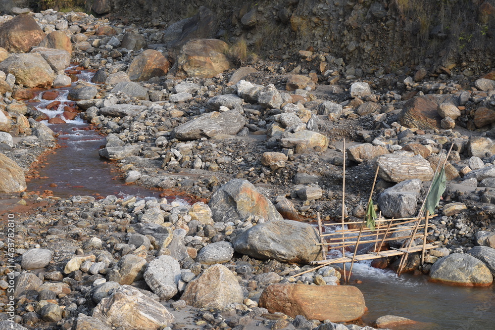 Obraz premium Villagers makeshift Bamboo bridge over high current river.