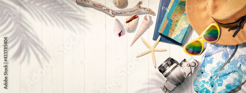 白いウッドデッキの上にある麦わら帽子、サングラス、ビーチサンダルなど夏のリゾートのイメージ。もしくは海外旅行のイメージ。真上からのアングル photo