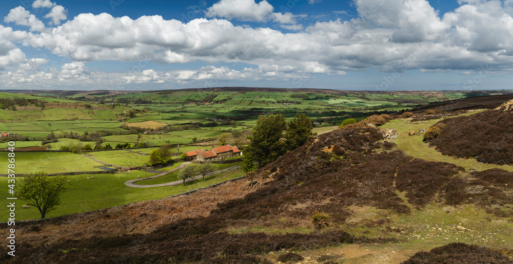 North York Moors with valley, fields, and heathland under blue sky. Glaisdale, UK.