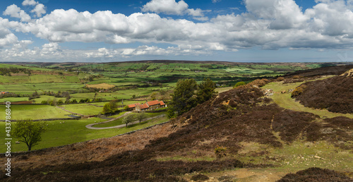 North York Moors with valley  fields  and heathland under blue sky. Glaisdale  UK.