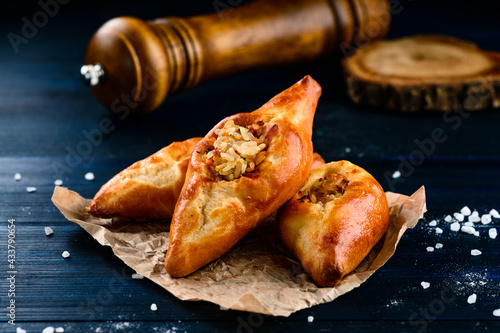 russian pie rasstegay with a hole on top, Traditional Russian, Slavic pies with hole in center. Rasstegay on wooden background photo