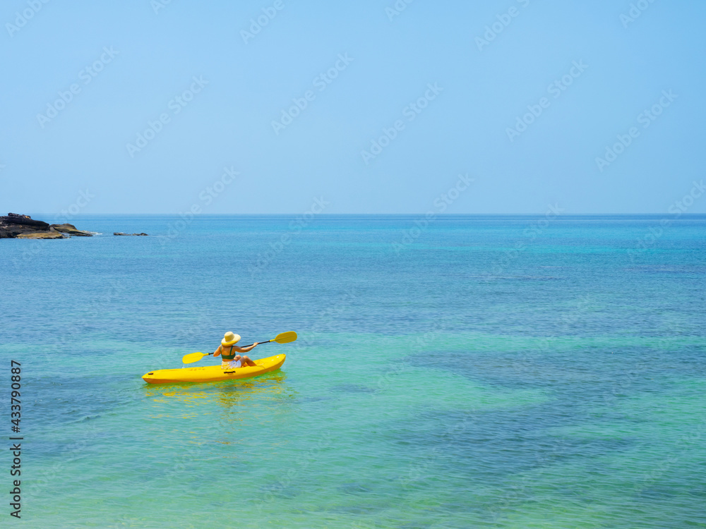 Asian tourist on yellow Kayak boat in tropical island blue sea bright sun in summer. Koh Kood - Thailand Asian tourist on yellow Kayak boat in tropical island blue sea bright sun in summer. Koh Kood - Thailand