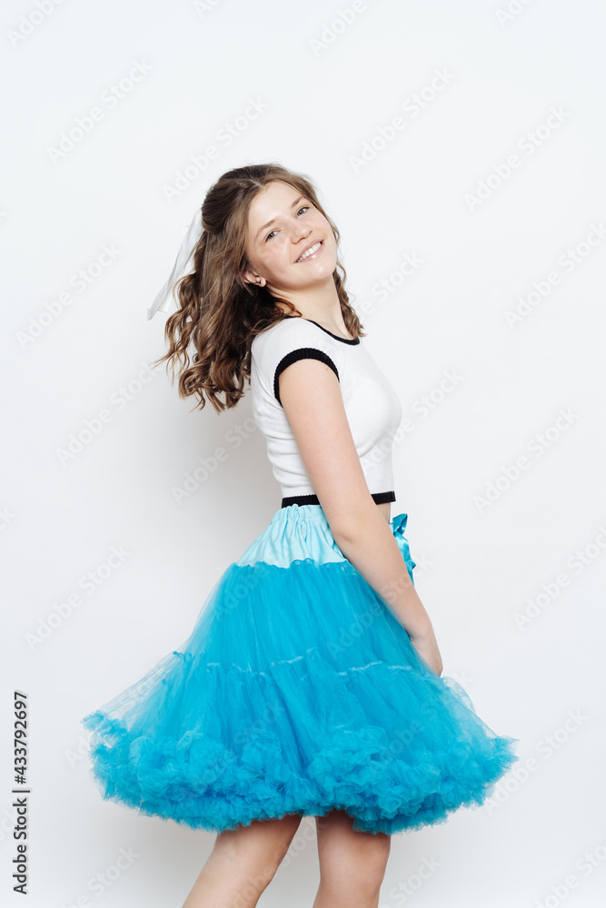 Happy stylish girl teenager posing with penny board on white background. Emotions concept Happy stylish girl teenager posing with penny board on white background. Emotions concept