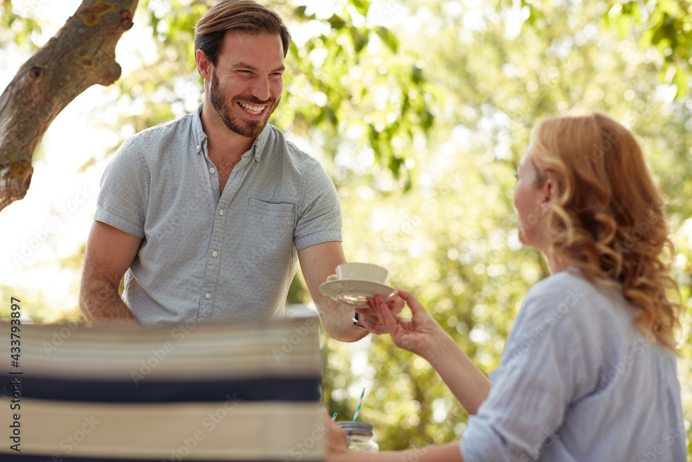 beardy husband giving a cup of coffee to his wife with smile beardy husband giving a cup of coffee to his wife with smile