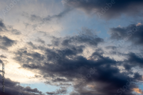 Background of dark clouds before a thunder-storm. Dramatically illuminated clouds in the evening sky.