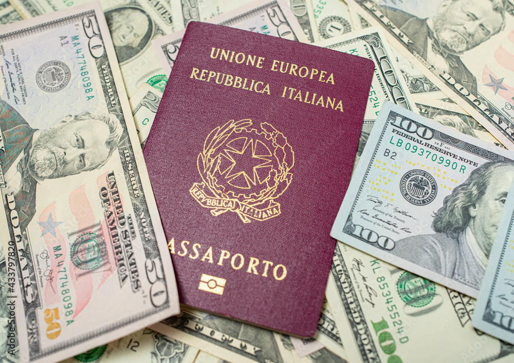 Italian Passport on top of dollar banknotes. One hundred and fifty USD bills. European Union Passport. Traveling to the United States. Italian Passport on top of dollar banknotes. One hundred and fifty USD bills. European Union Passport. Traveling to the United States.
