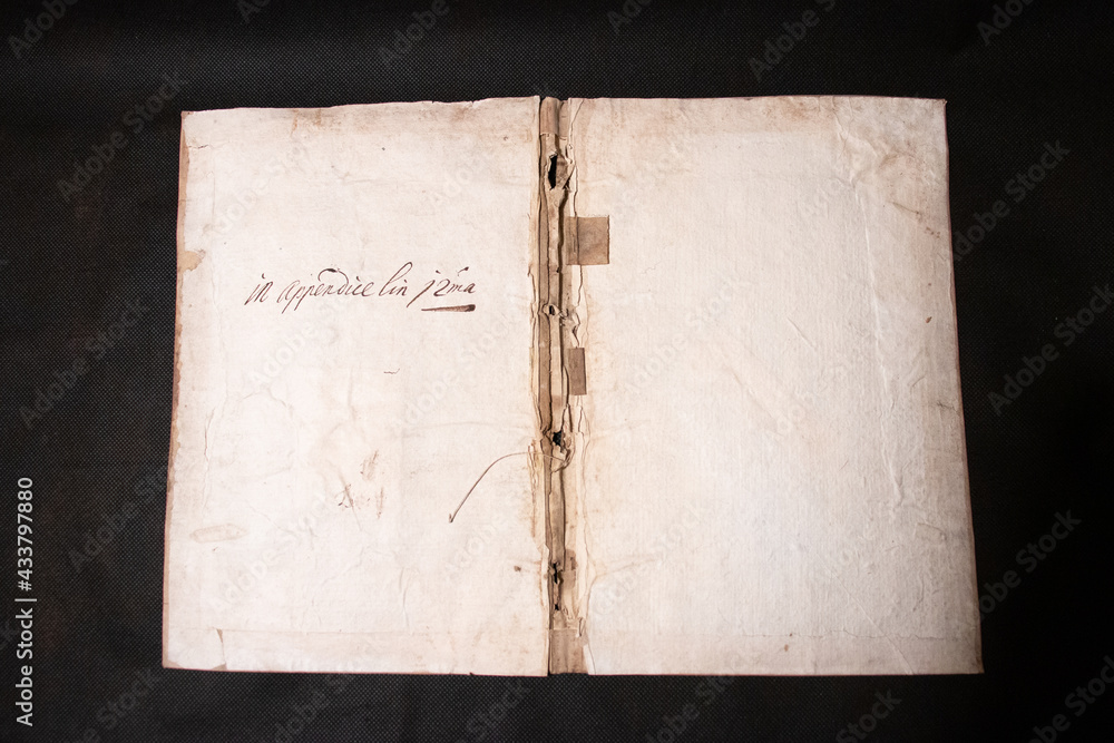 A medieval manuscript hand written onto parchment or vellum and illuminated with red initial