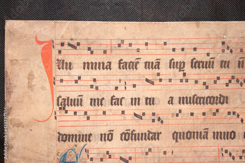 Fotografie A medieval manuscript hand written onto parchment or vellum and illuminated with red initial flourishes in pen