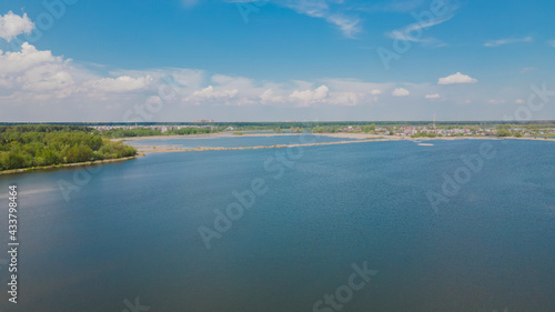 View of the coastline with a beautiful pond from a height. Panoramic photo over blue water. Design of wallpapers, photo wallpapers, backgrounds, screensavers, covers.