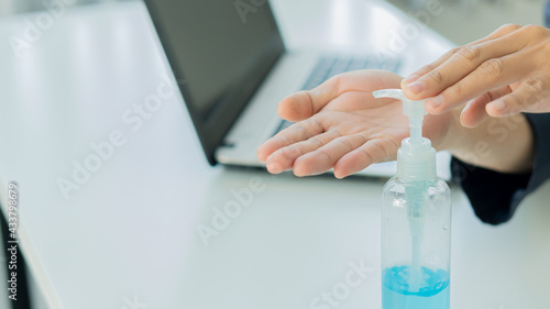 Business people wash their hands with gel in the office and a bottle of gel placed on the table