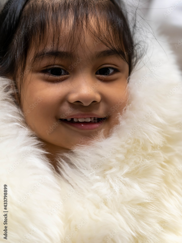 Pretty asian child wearing a white coat made of fur. Pretty asian model wearing white fur coat Pretty asian child wearing a white coat made of fur. Pretty asian model wearing white fur coat