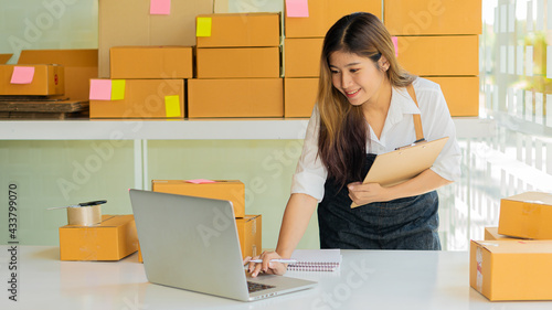 Small business owners working with laptops and telephones, mobile and cardboard boxes at work, small business entrepreneurs, SME working with boxes at home, selling online, e-commerce.