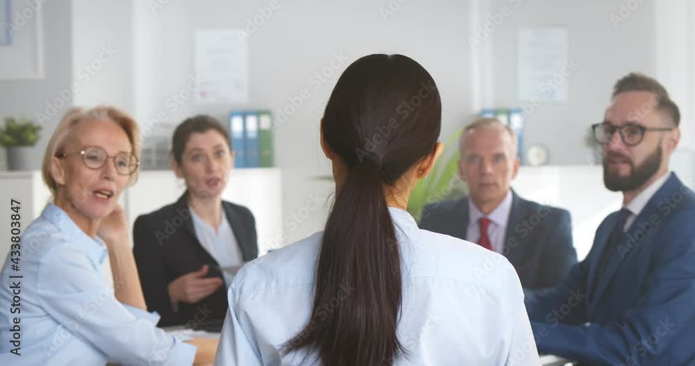 Group of business people sitting around office desk and discussing project together Group of business people sitting around office desk and discussing project together