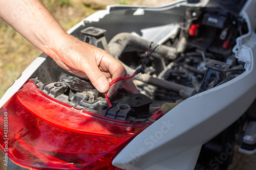 Repair and dismantling of a motorcycle. The man disconnected the taillight wires from the power supply