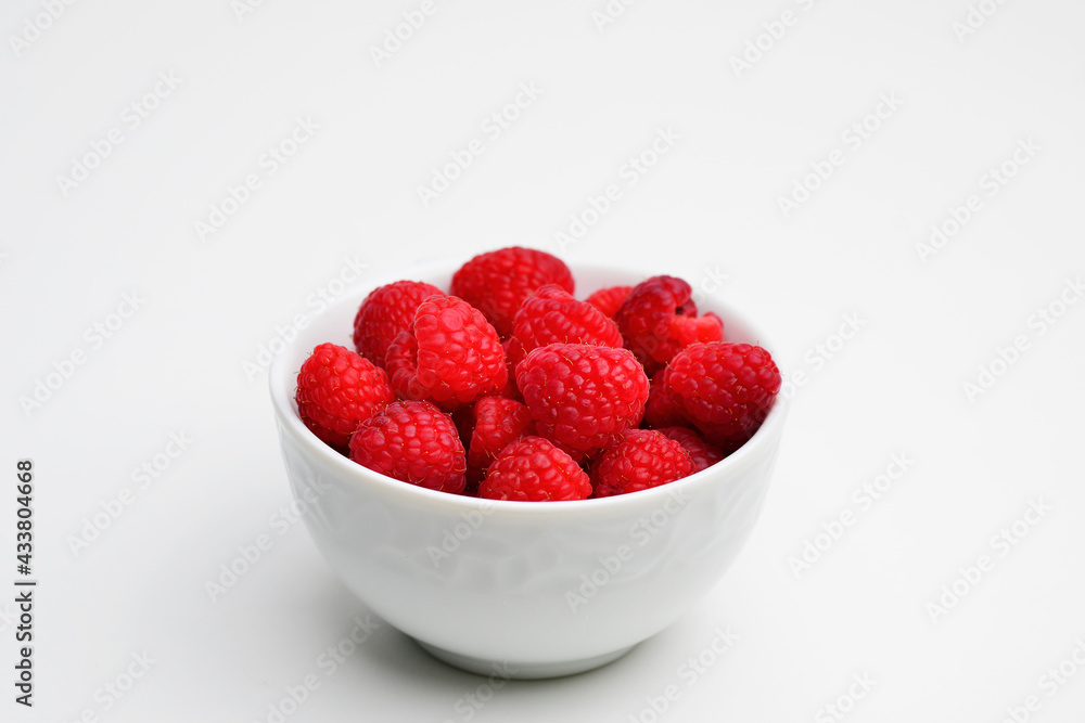 Bowl of fresh raspberries on white background. Flat lay, top view, copy space. Raspberries isolated on white background. Raspberries Clipping Path. Mint Raspberries macro studio photo. Bowl of fresh raspberries on white background. Flat lay, top view, copy space. Raspberries isolated on white background. Raspberries Clipping Path. Mint Raspberries macro studio photo.
