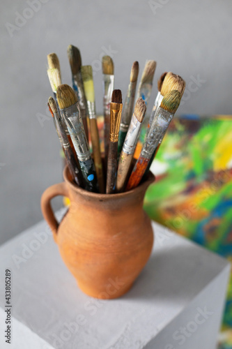 Paint brush in clay jug on table background texture. Paintbrush painting and art still life