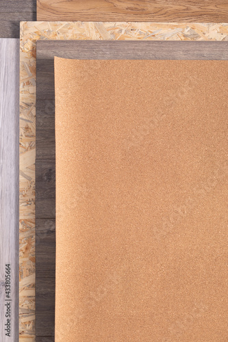 Cork roll and laminate floor on wood osb background texture. Cork background at wooden laminate floor