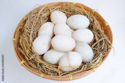 Duck eggs in bamboo basket on white background