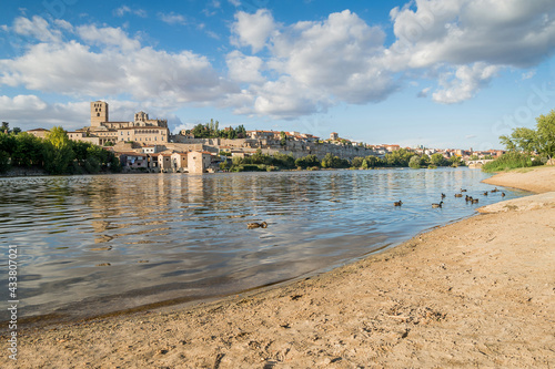 Cityscape and old town with 12th century Romanesque cathedral, water mills and stone bridge over the Duero River in Zamora, Castilla y León, Spain.