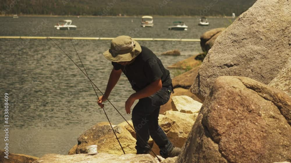 Fisherman frustrated kneeling to put the bait on the fishing line Fisherman frustrated kneeling to put the bait on the fishing line