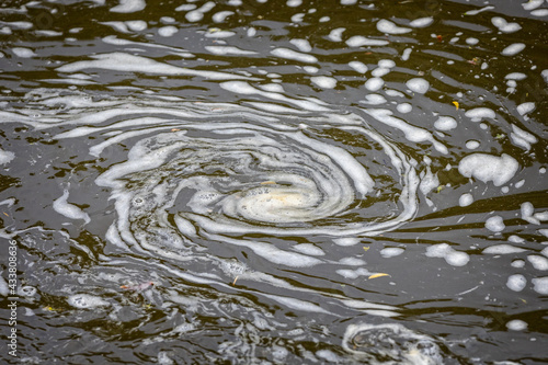 Swirl of water foam in shape of a spiral on river surface