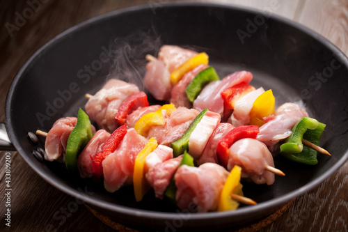 Chicken skewers cooking in a pan. High quality photo.