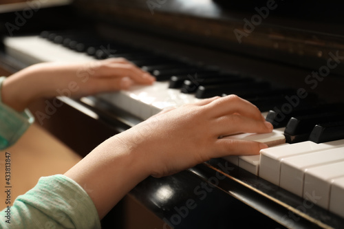 Little child playing piano, closeup. Music lesson