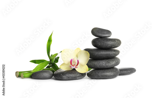 Spa stones, beautiful orchid flower and bamboo stems on white background