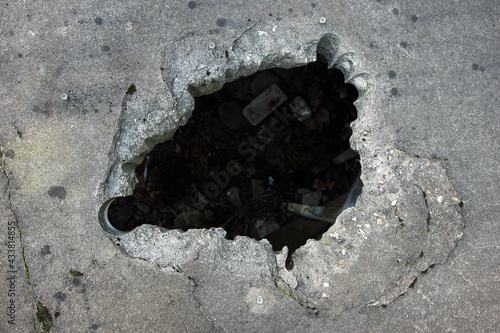 Large dark hole in the concrete floor.