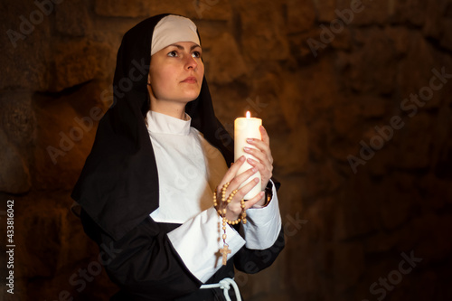Konstfotografi Young nun devoutly with candle