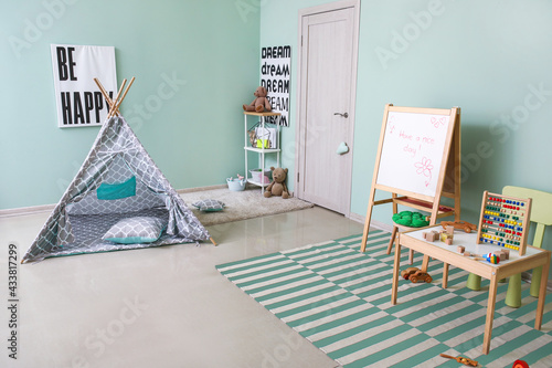 Stylish interior of modern children's room with soft carpet