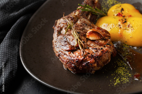 Roasted steak in frying pan on dark background