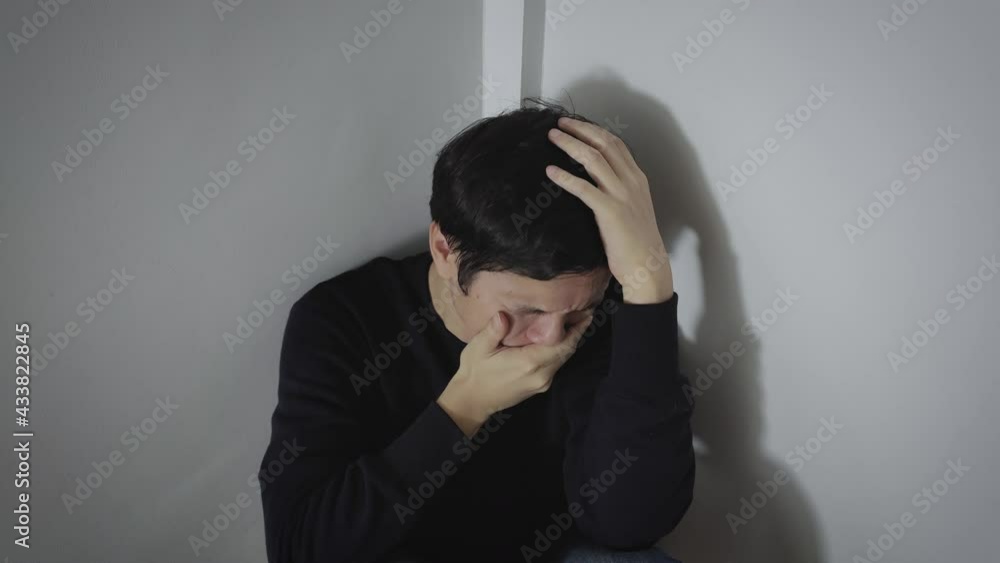A man sitting and crying A man sitting and crying