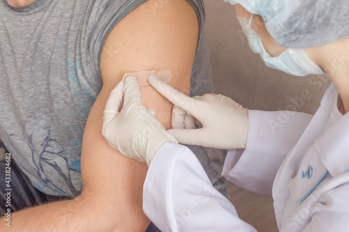 A nurse puts a band-aid on the patient's arm after the procedure.