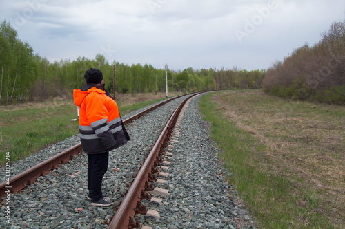 Railroad worker foreman supervises repair of road tracks